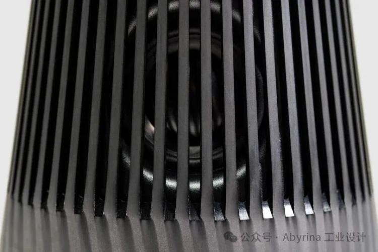 Close-up view of a Bang & Olufsen black speaker grill with vertical slats, revealing part of the speaker cone behind the grill.