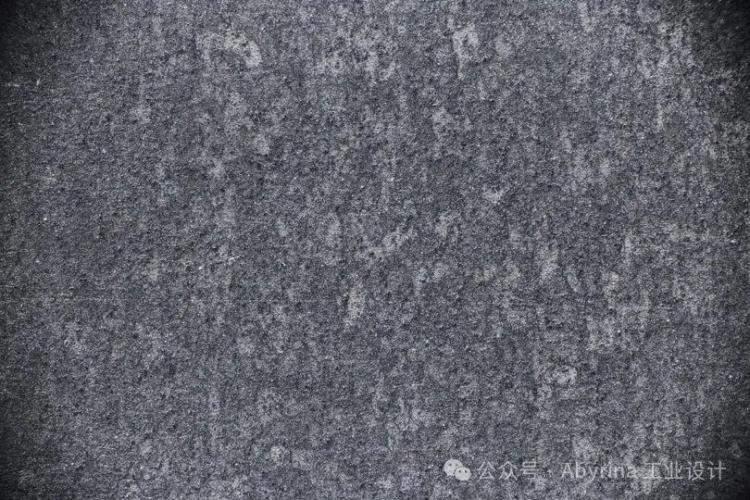 Rough, dark gray concrete surface with visible texture and subtle shading variations, reminiscent of the sophisticated finishes seen in Bang & Olufsen designs.