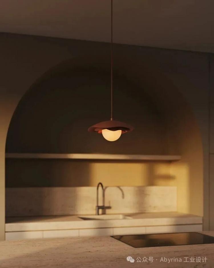 A modern pendant light hangs over a minimalist kitchen with a marble countertop, built-in sink, and arched alcove in warm lighting.