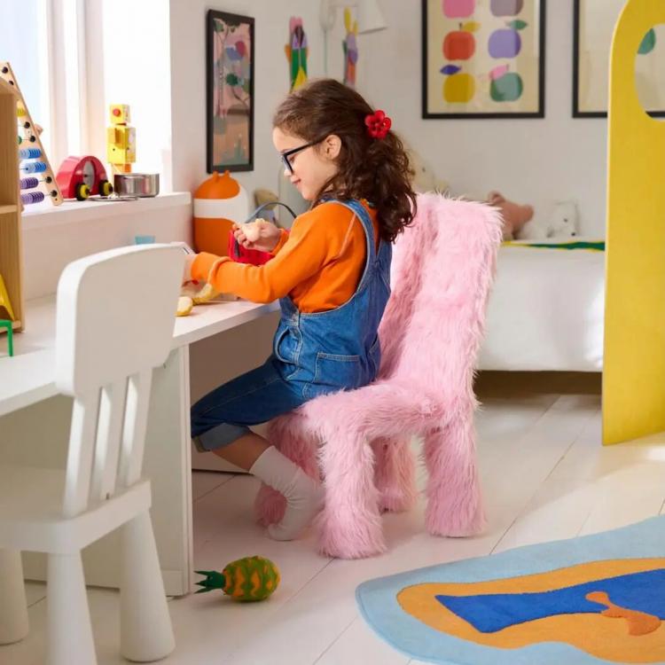 Child engaging in play at a colorful workspace.
